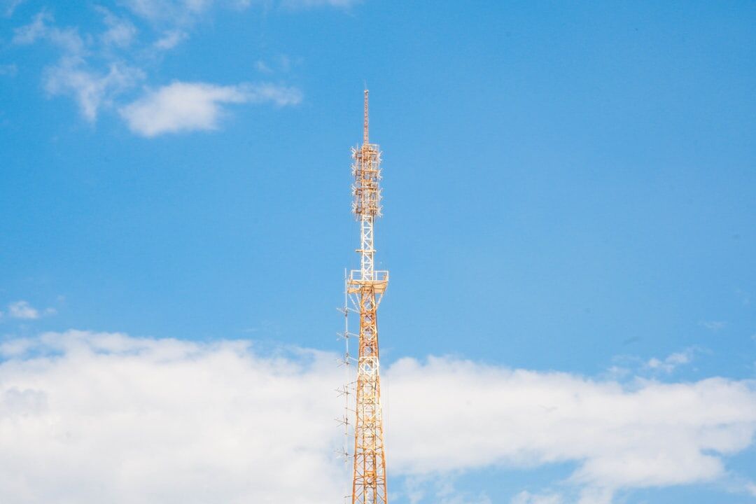 Mobile network communication tower against a bright sky