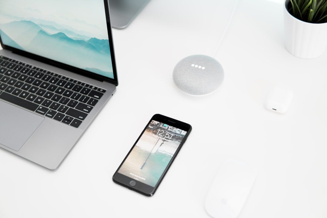 Modern desk with a smartphone, laptop and wireless earbuds displaying technology news